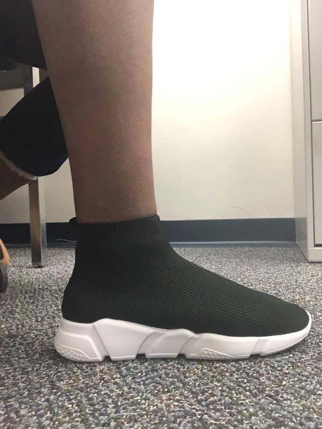 A idiosyncratic   wearing achromatic  sock-style sneakers with achromatic  soles