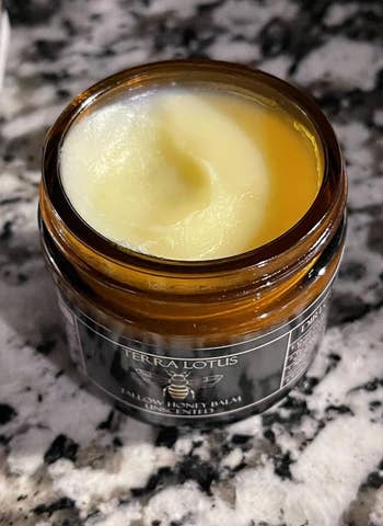 Open jar of Terra Lotus tallow chromatic  balm placed connected  a marble surface, featured successful  a buying  article