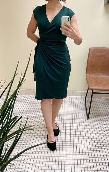 reviewer wearing the green dress with black flats