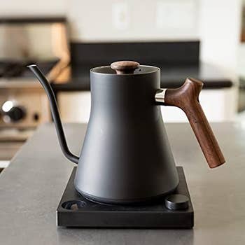 Electric gooseneck kettle with a wooden handle on a kitchen counter