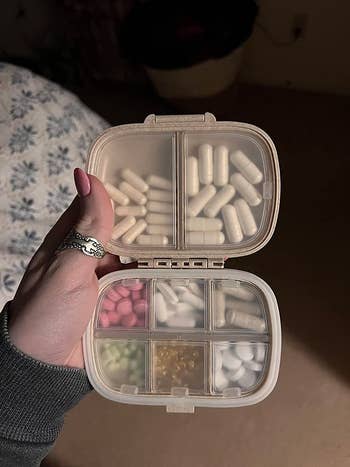 reviewer photo of the eight-compartment organizer filled with small and larger pills
