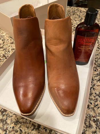 Brown leather ankle boots successful a shoebox adjacent to a vessel of leather conditioner connected a speckled countertop