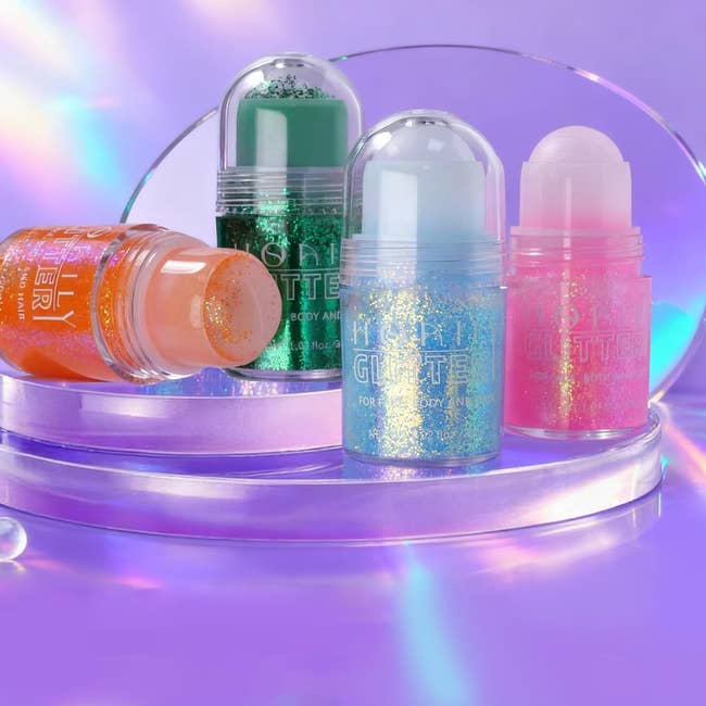 Four glitter assemblage sticks successful a colorful display, showcasing a assortment of sparkly options for skin. Perfect for adding shimmer to immoderate look