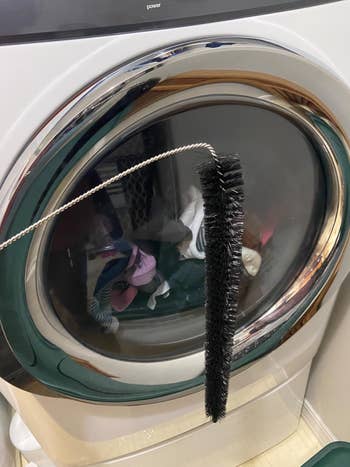 reviewer photo of the black lint brush in front of a full dryer