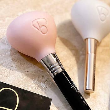 reviewer's pink and white case protecting two makeup brushes