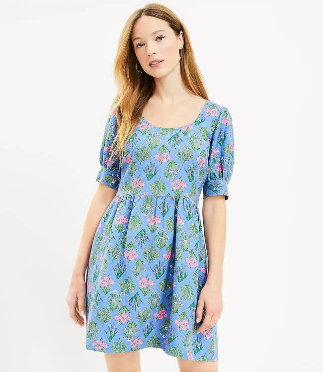 model in blue short sleeve dress with pink green yellow and white floral print