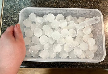 A reviewer's bin of ice spheres with scoop