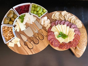 reviewer's charcuterie board with meat and cheeses on it and a part of it swung out