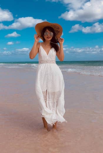 reviewer wearing white sundress on the beach