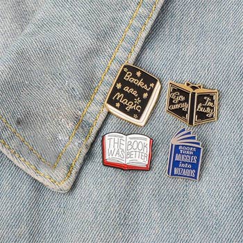 four pins pinned on a denim jacket