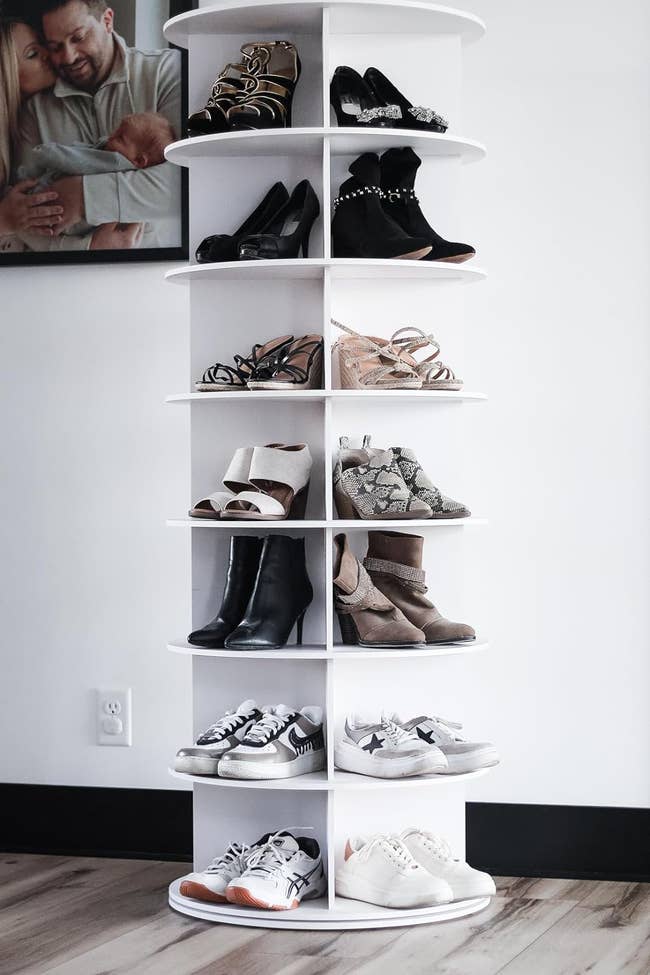 A variety of women's and men's shoes displayed on a white shelving unit, for shopping context