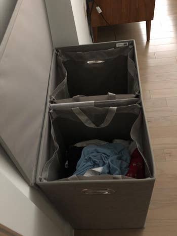 Laundry sorter with removable fabric bins, one filled with clothes, in a home setting