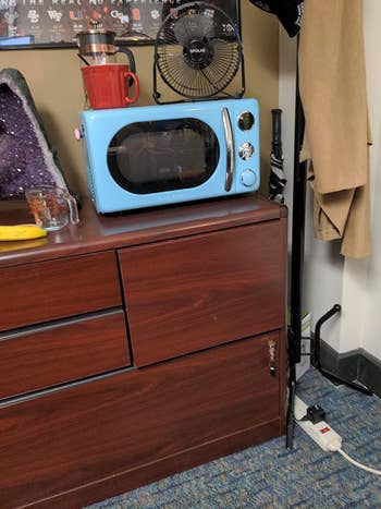 a reviewer photo of the microwave on top of a dresser