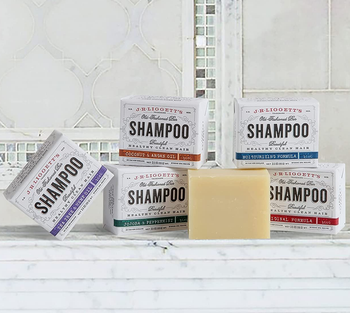 Five assorted shampoo bars in a bathroom counter