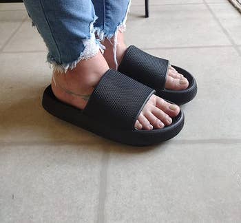 a reviewer wearing the rubber slides in black 