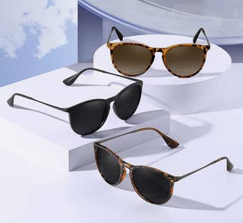 Three pairs of sunglasses displayed on geometric stand