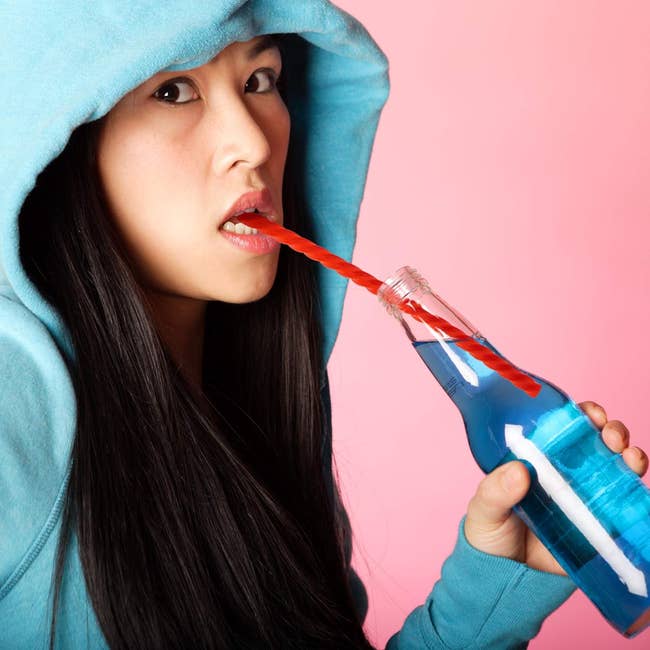 model drinking out of straw that looks like red licorice