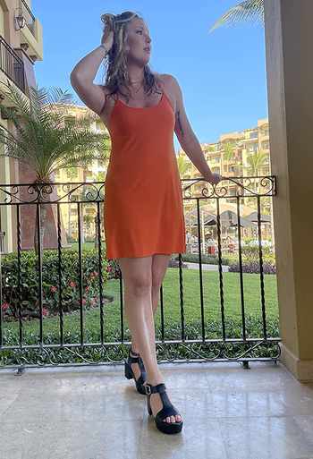 reviewer wearing the black heels with a sun dress