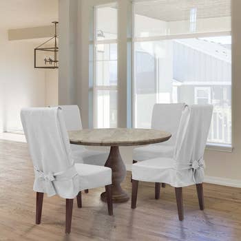 chairs with oatmeal slipcovers surrounding table