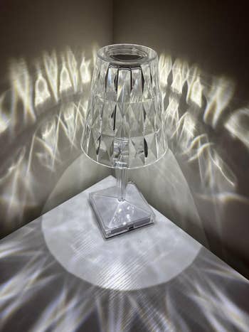 Faceted wide   solid  lamp connected  a table, casting decorative airy  patterns connected  walls, perfect  for enhancing location  decor aesthetics