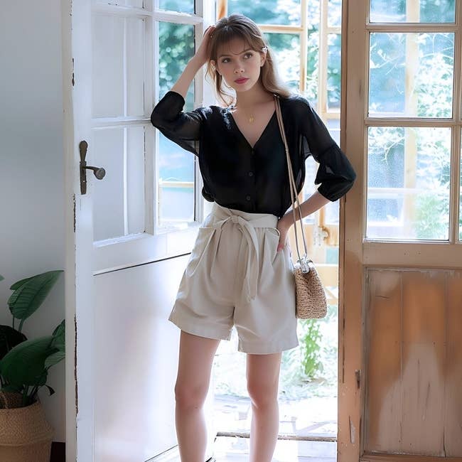 model wearing the beige belted shorts with achromatic blouse