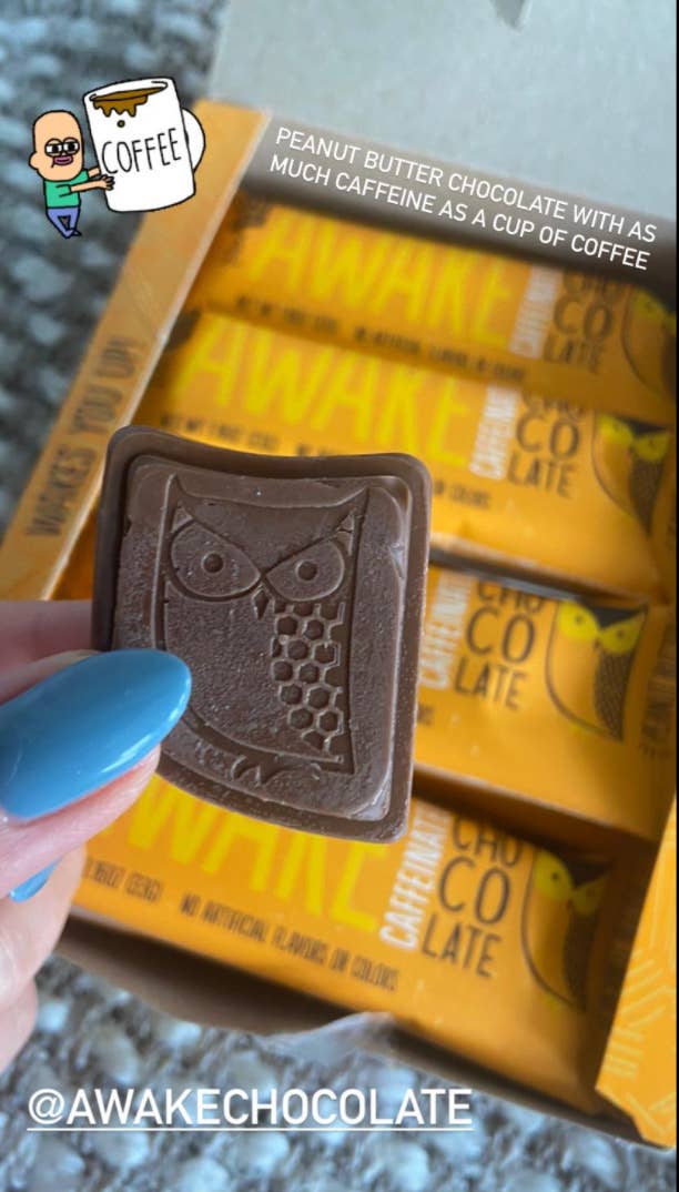 Reviewer holding up a square of chocolate with an owl on it 