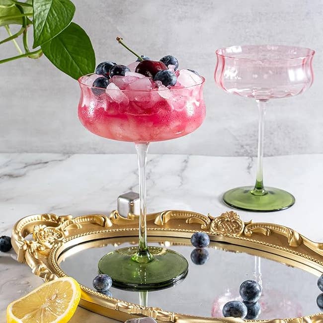 Elegant cocktail successful  a solid  with a greenish  stem, topped with ice, blueberries, and a cherry, connected  a decorative tray