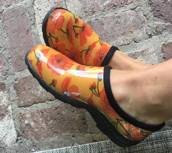 Reviewer's yellow clogs with orange flowers