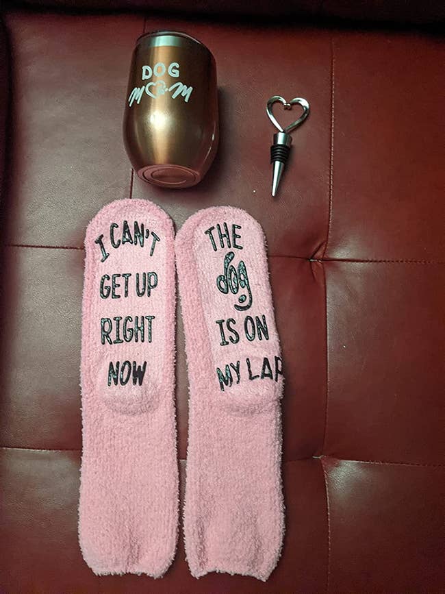 Reviewer image of dog-themed pink fuzzy socks, a wine tumbler, and heart-shaped wine bottle cap