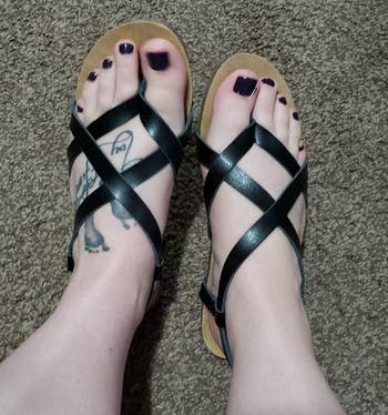 a reviewer wearing the strappy leather sandals in black 