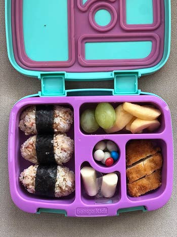 reviewer photo of the inside of the purple and teal lunchbox filled with food