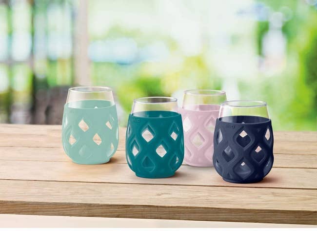 four glasses with mint, teal, lavender, and navy silicone sleeves