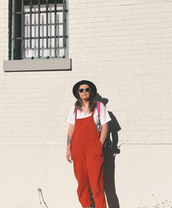 reviewer wearing the brick red overalls outside