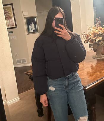 reviewer wearing a navy cropped puffer with jeans