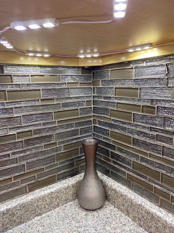 reviewer showing what the lights looks like on the underside of the cabinet