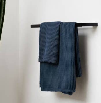 the towels in navy on a towel rack
