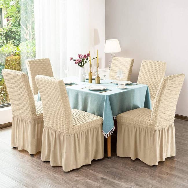 chairs at dining table with cream textured full-length slipcovers