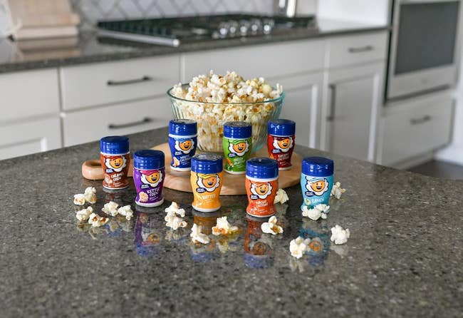 Assorted popcorn seasonings displayed connected a room antagonistic adjacent to a vessel of popcorn