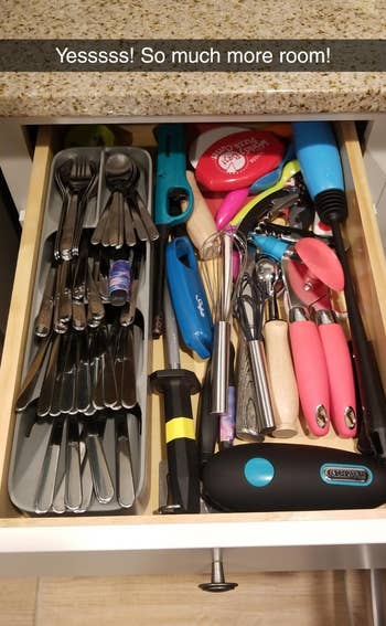 reviewer pic of the cutlery organizer in a drawer, with other utensils next to it