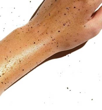 the shimmering coffee scrub on another model's hand and forearm