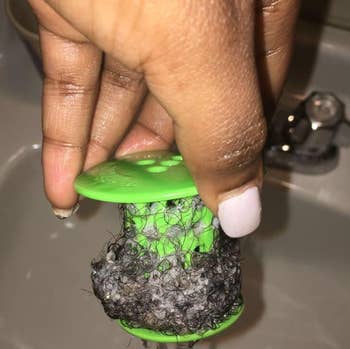 reviewer showing natural coils of hair caught in tub shroom 