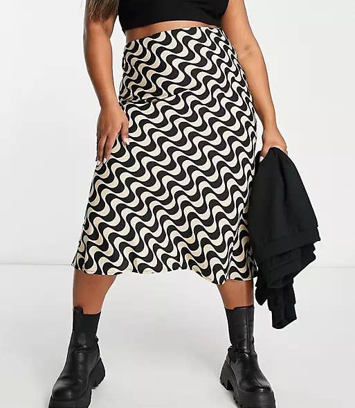 model wearing the black and taupe wavy print slip skirt