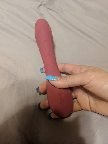 Hand holding vibrator from different angle to display texture and buttons