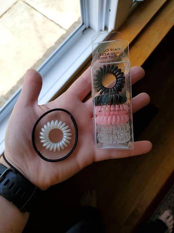 Reviewer photo of the spiral hair ties compared to the larger size of a regular hair tie