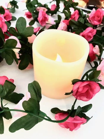 a reviewer's faux flowers around a candle