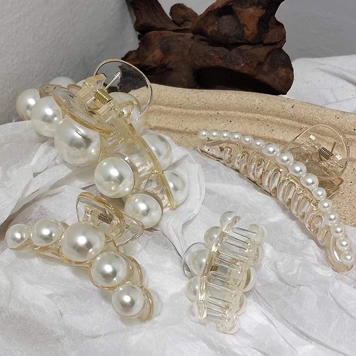 four pearl claw clips of varying sizes