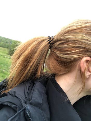 A reviewer showing their low ponytail with the hair tie in black