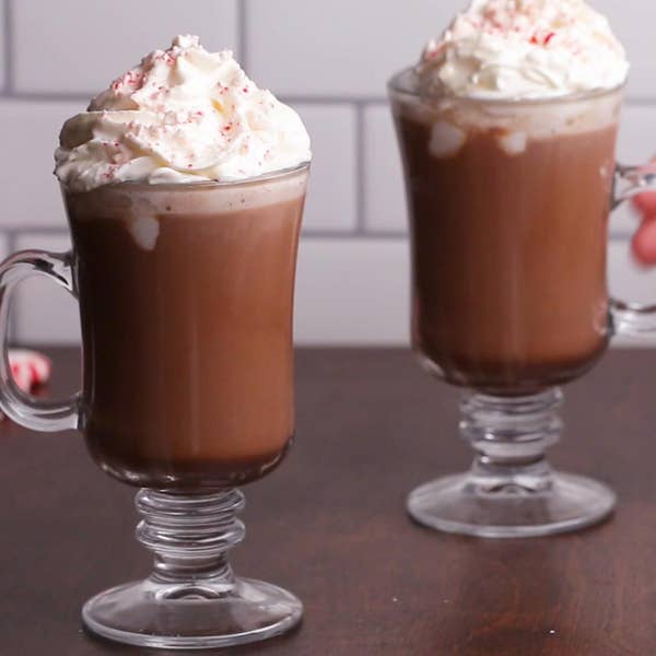 Two cups of coffee cocktails with whipped cream in glass mugs