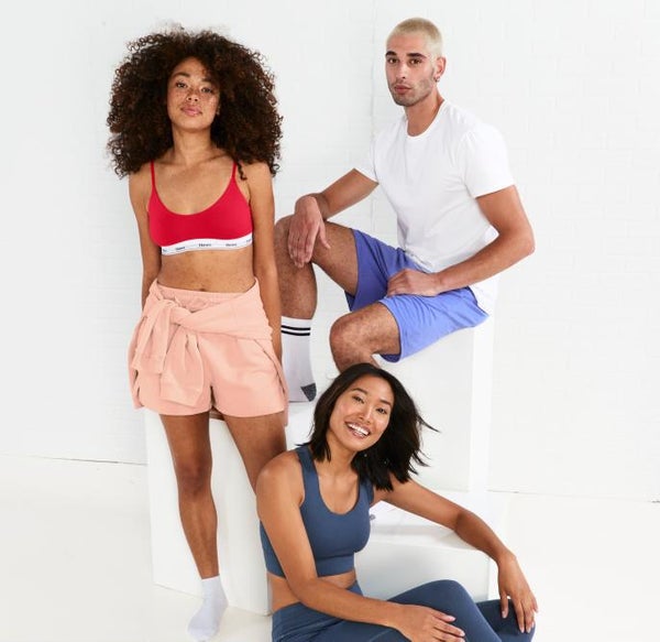 Models lounge in leggings, bras, shorts, and shirts from the Hanes Originals Collection