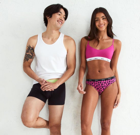 Man wears boxers and tank while woman wears bra and underwear from the Hanes Originals Collection